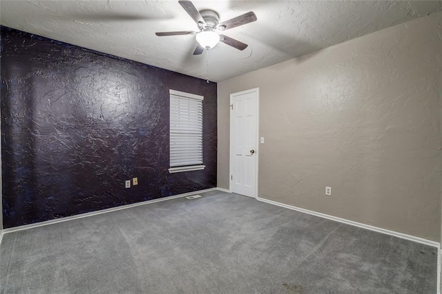 carpeted empty room featuring ceiling fan and a textured ceiling