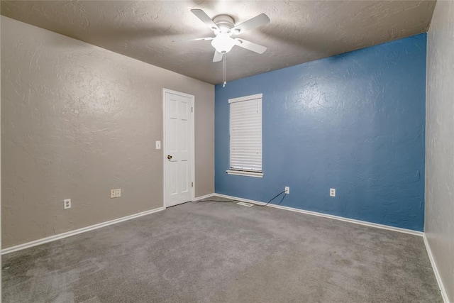 carpeted spare room with ceiling fan and a textured ceiling