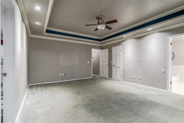 empty room featuring crown molding, ceiling fan, a raised ceiling, and carpet floors