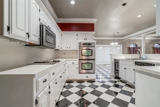 kitchen with white cabinetry, ornamental molding, and stainless steel appliances