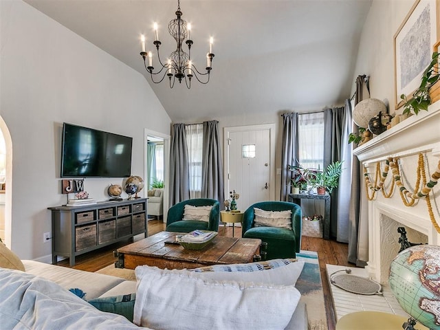 living room featuring hardwood / wood-style flooring, lofted ceiling, and an inviting chandelier