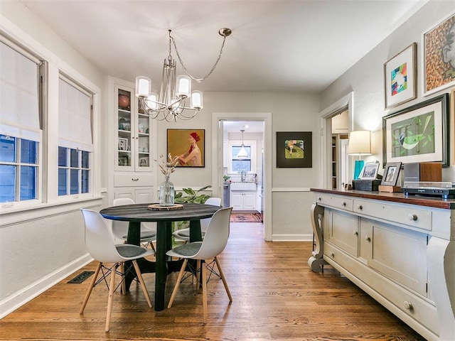 dining area with wood-type flooring and a chandelier