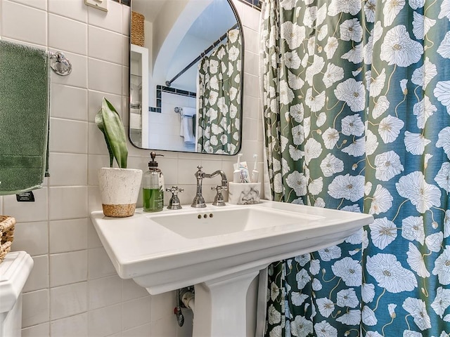 bathroom with tile walls, sink, and decorative backsplash