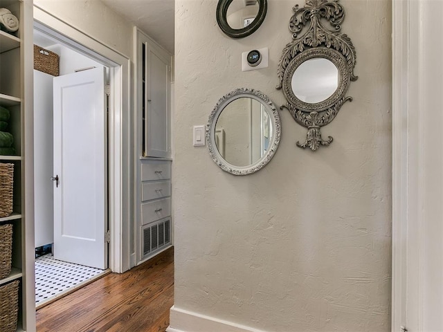 corridor with dark hardwood / wood-style floors and built in features