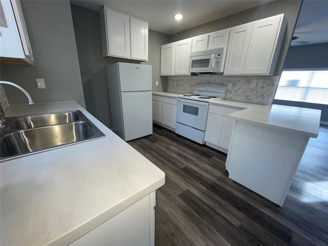 kitchen featuring dark wood-type flooring, sink, white appliances, decorative backsplash, and white cabinets