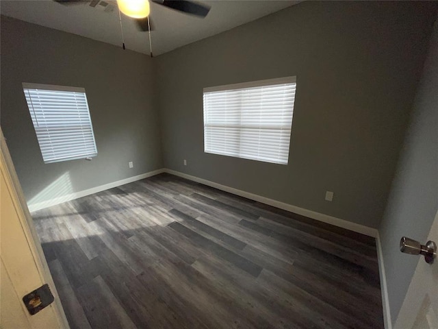 empty room with ceiling fan and dark hardwood / wood-style flooring