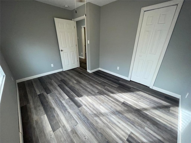 unfurnished bedroom with a closet and dark hardwood / wood-style floors