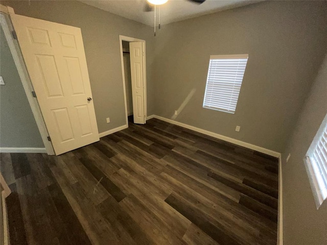 unfurnished bedroom with ceiling fan and dark hardwood / wood-style flooring