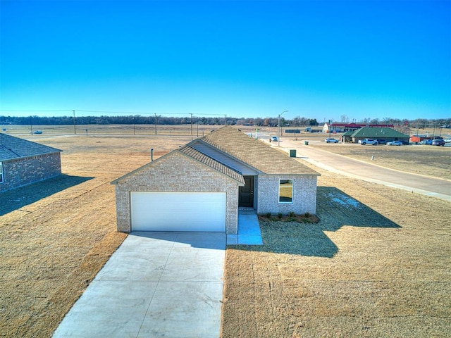 view of front of home featuring a garage and a rural view