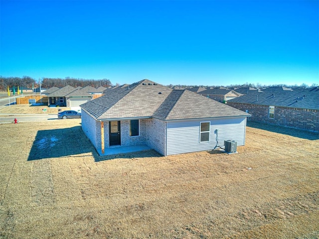 rear view of property with cooling unit and a lawn