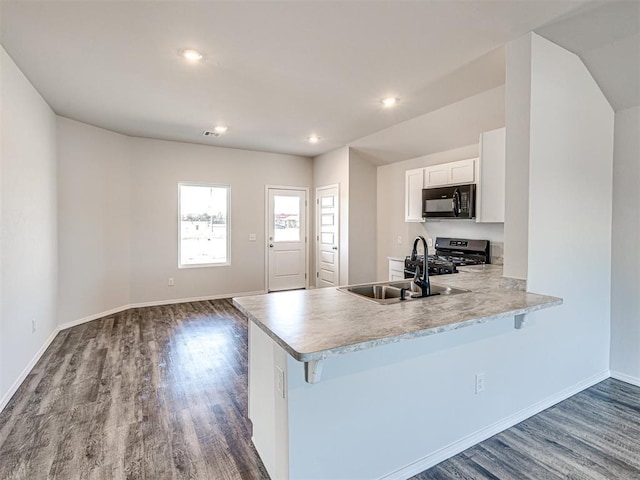 kitchen featuring sink, white cabinetry, hardwood / wood-style floors, range with gas cooktop, and kitchen peninsula