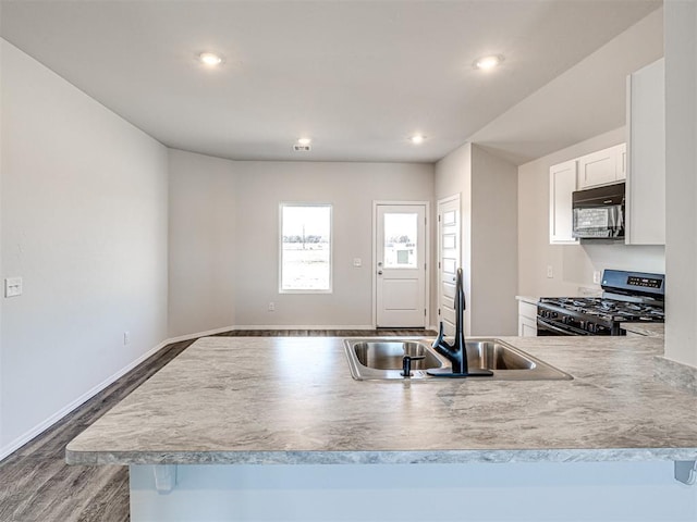 kitchen featuring white cabinetry, sink, dark wood-type flooring, and black appliances