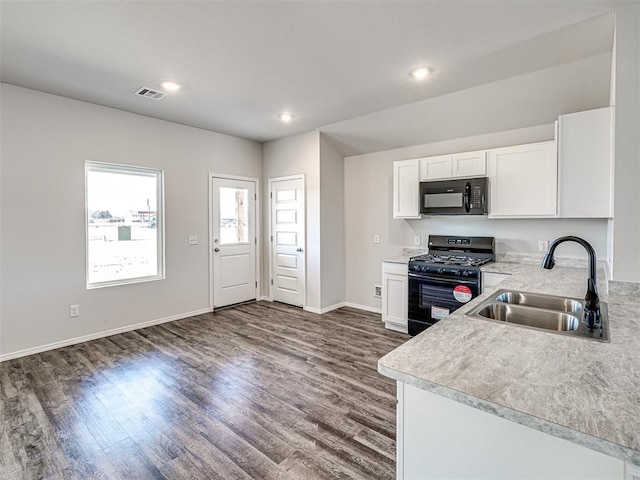 kitchen featuring sink, dark wood-type flooring, black appliances, and white cabinets