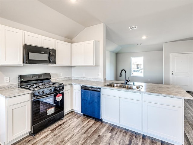 kitchen with white cabinetry, sink, black appliances, and kitchen peninsula