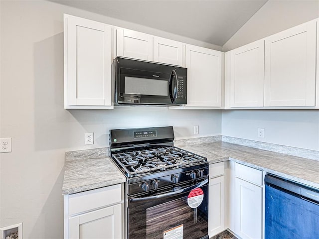 kitchen featuring white cabinetry, black appliances, and lofted ceiling