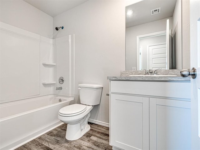 full bathroom featuring vanity, hardwood / wood-style floors, shower / bathtub combination, and toilet