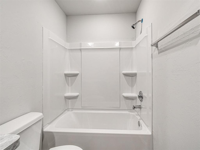 bathroom featuring bathtub / shower combination and toilet