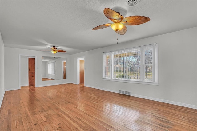 unfurnished living room with ceiling fan, a textured ceiling, and light hardwood / wood-style floors