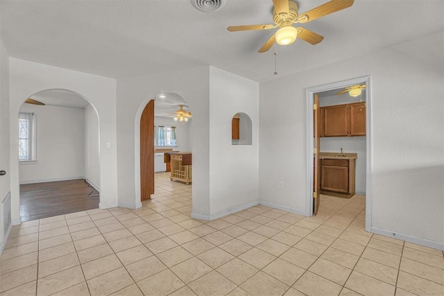 spare room featuring ceiling fan and light tile patterned floors