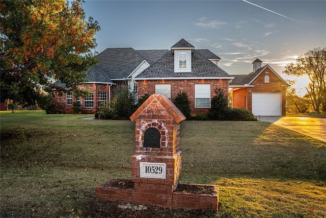 view of front of home with a garage and a lawn