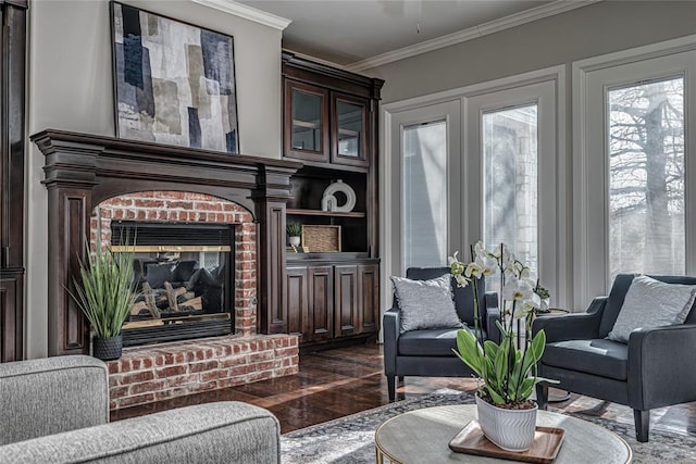 living room featuring a brick fireplace, dark wood-type flooring, and ornamental molding