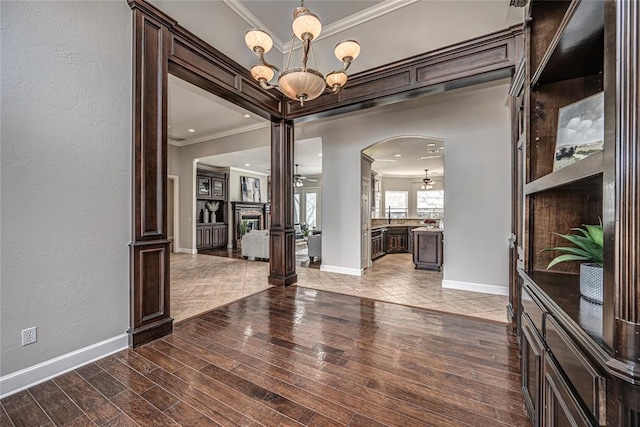 interior space featuring hardwood / wood-style flooring, ornamental molding, and ceiling fan with notable chandelier