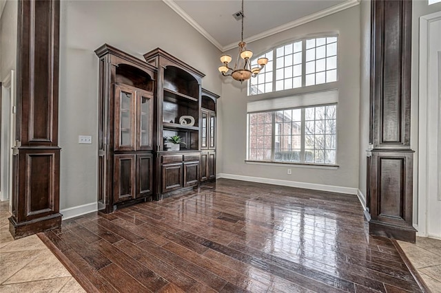 dining room featuring crown molding, dark hardwood / wood-style floors, an inviting chandelier, and a high ceiling