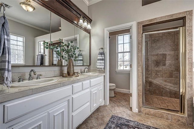 bathroom with a wealth of natural light, ornamental molding, and toilet