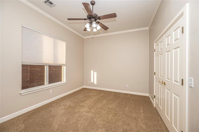 carpeted empty room featuring crown molding and ceiling fan