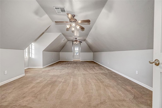 bonus room featuring vaulted ceiling, light colored carpet, and ceiling fan