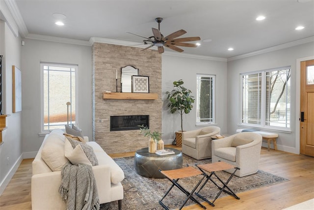 living room with a fireplace, ornamental molding, and light wood-type flooring