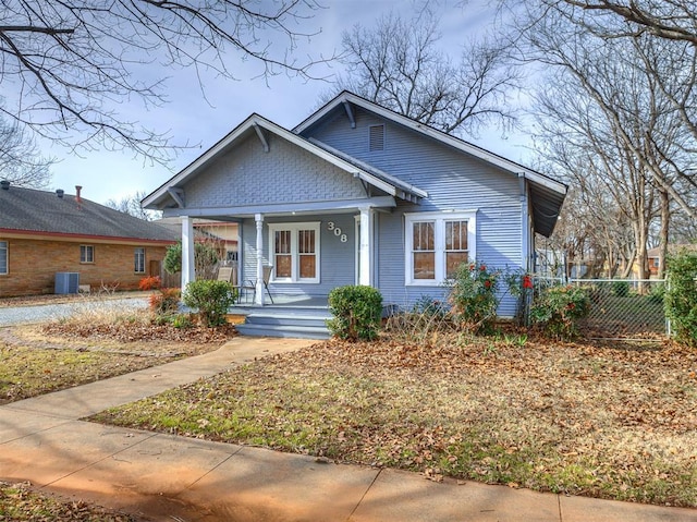 bungalow-style house with central AC unit and a porch