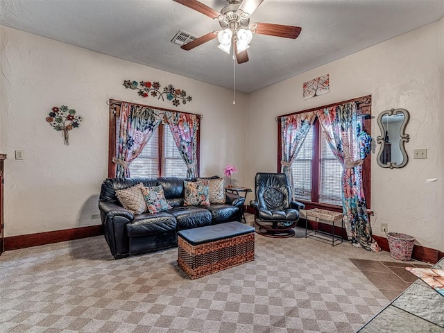 carpeted living room with a textured ceiling and ceiling fan