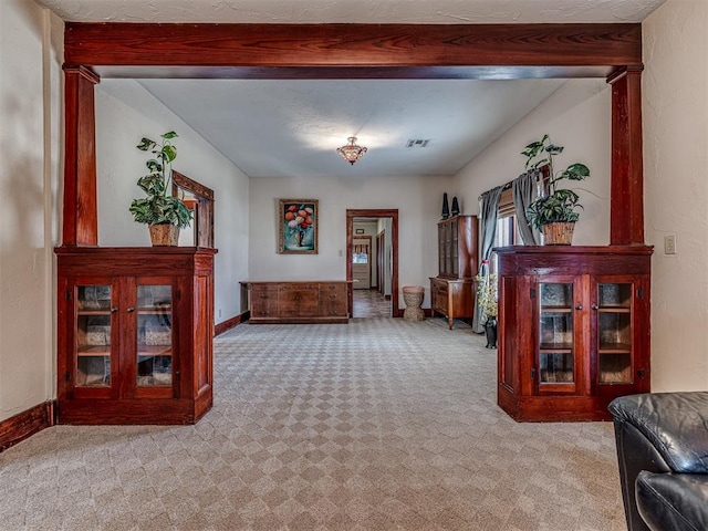 sitting room with light colored carpet and beam ceiling