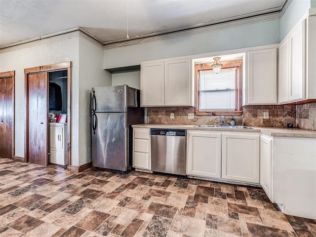 kitchen featuring sink, crown molding, stainless steel appliances, washer / clothes dryer, and white cabinets