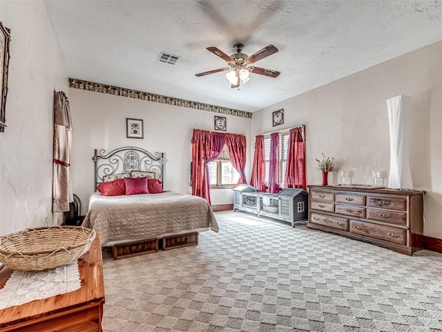 carpeted bedroom with ceiling fan and a textured ceiling