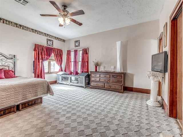 carpeted bedroom featuring ceiling fan and a textured ceiling