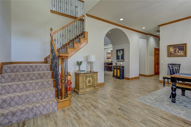 stairs featuring hardwood / wood-style flooring and ornamental molding