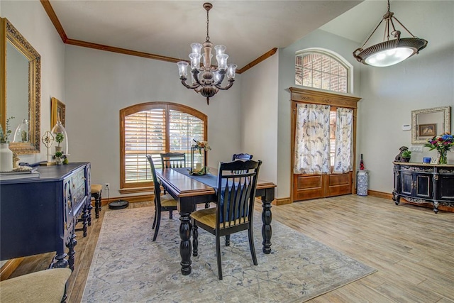 dining space featuring crown molding, wood-type flooring, a chandelier, and a high ceiling