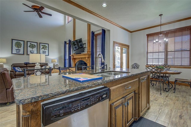 kitchen featuring dishwasher, sink, hanging light fixtures, ornamental molding, and a center island with sink