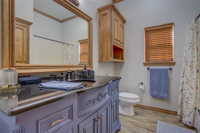 bathroom featuring crown molding, hardwood / wood-style floors, vanity, a shower with curtain, and toilet