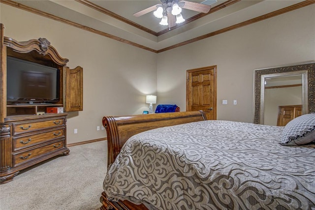 carpeted bedroom featuring a tray ceiling, ornamental molding, and ceiling fan