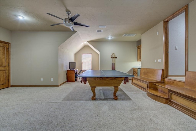 recreation room featuring light carpet, ceiling fan, and a textured ceiling