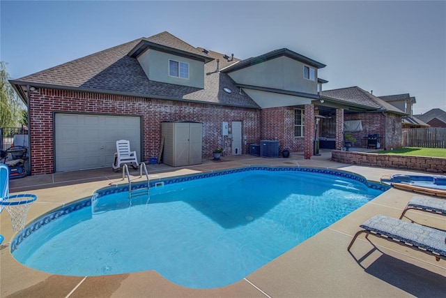 view of pool with an in ground hot tub, central AC unit, and a patio