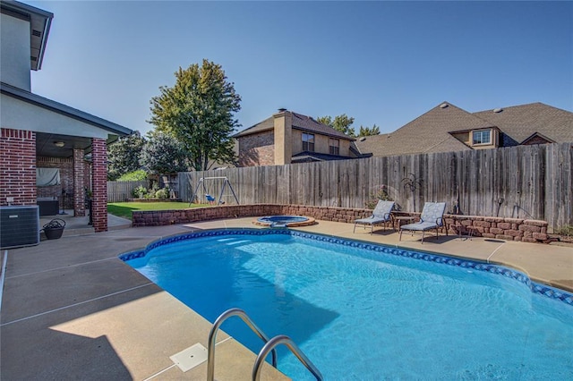 view of pool with an in ground hot tub, cooling unit, and a patio