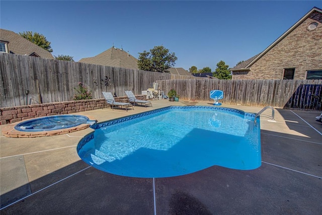 view of pool featuring a patio area and an in ground hot tub