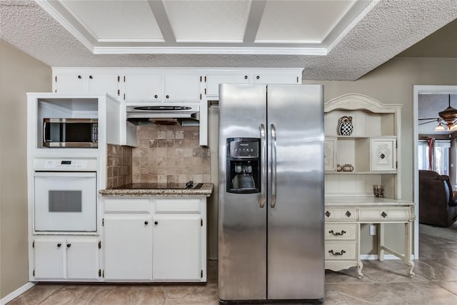 kitchen with stainless steel appliances, white cabinetry, backsplash, and ceiling fan