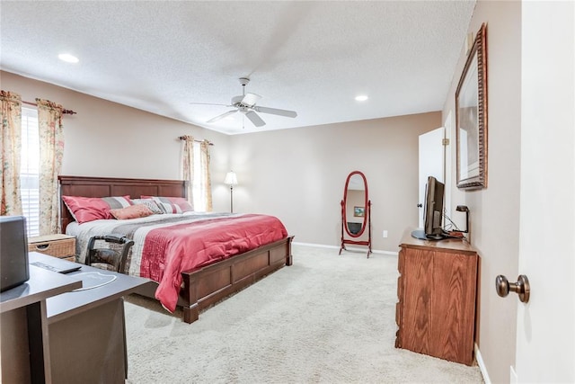 carpeted bedroom featuring ceiling fan and a textured ceiling