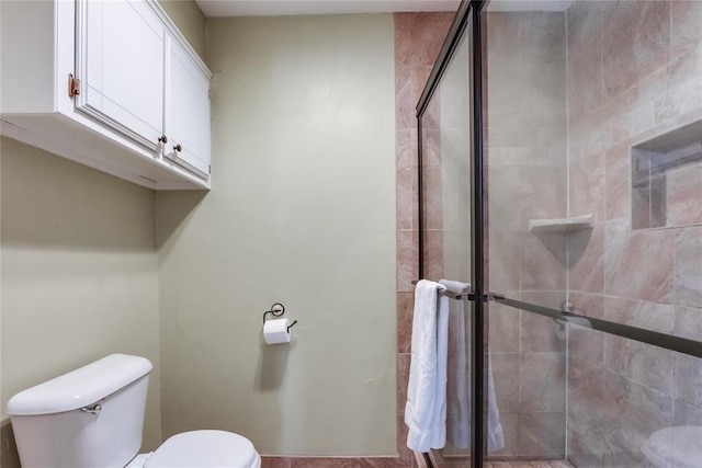 bathroom with toilet and an enclosed shower