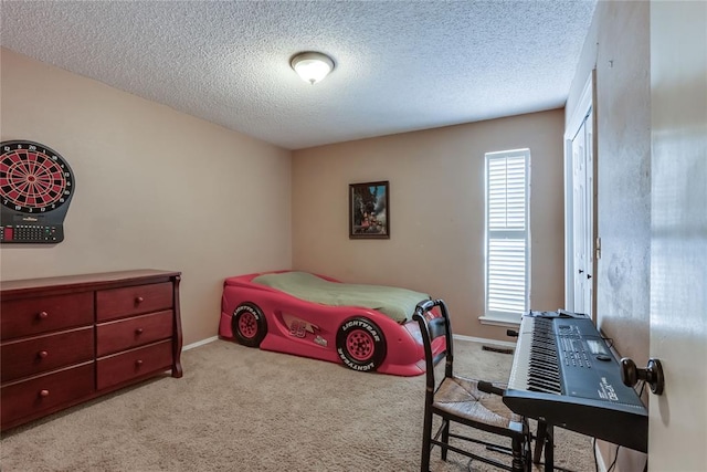 bedroom featuring light colored carpet, a textured ceiling, and a closet